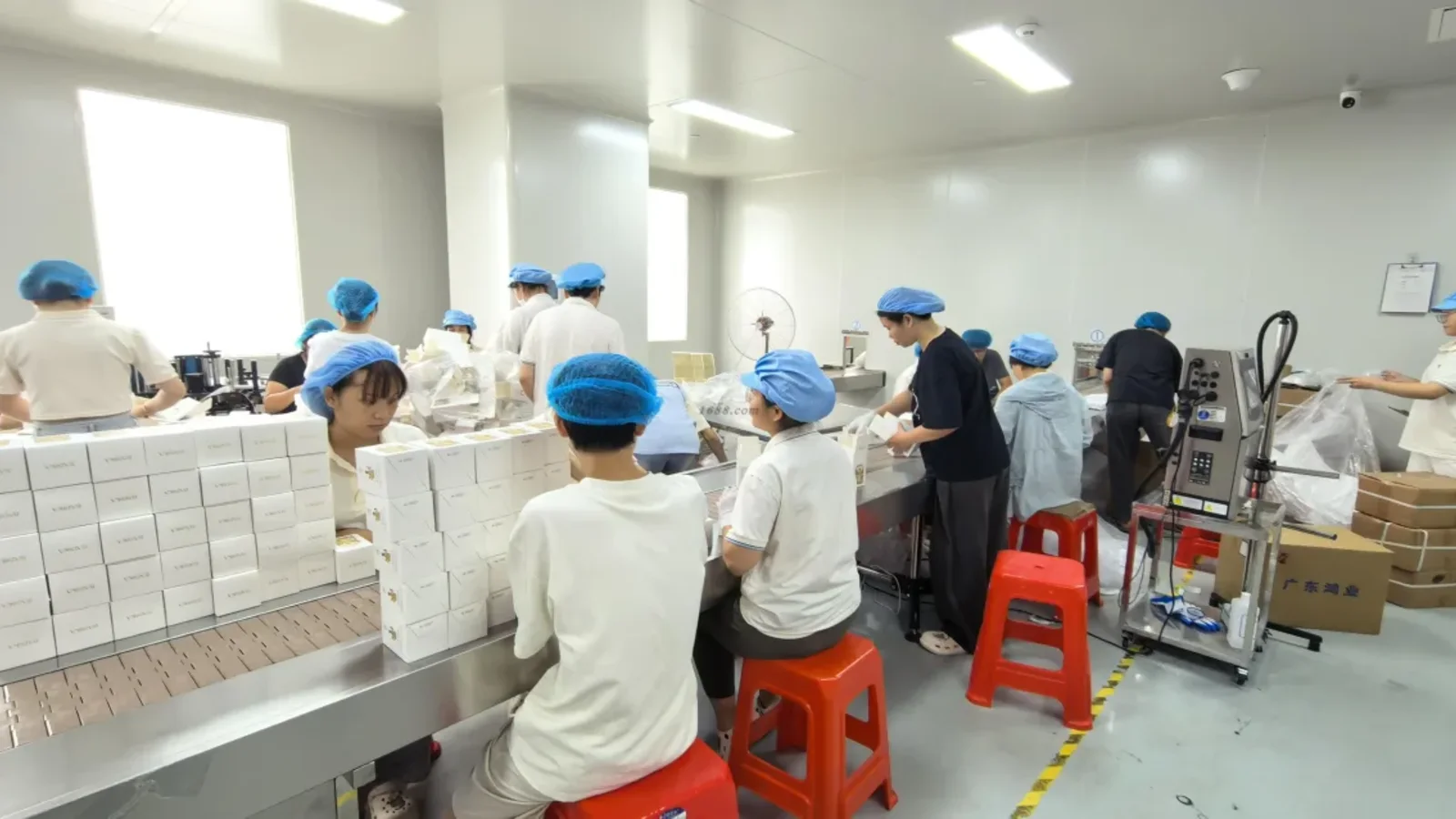 Equipo de fábrica montando y embalando perfumes terminados, relacionado con el plazo de producción de perfumes